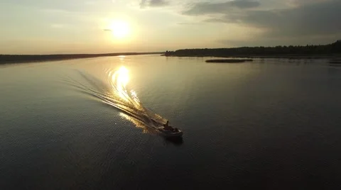 A rubber powerboat fast floating on the river at sunset. Aerial view. Stock Footage 64818150
