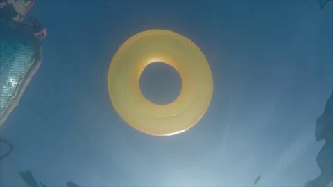 Rubber ring floating in transparent blue tiled pool Vidéo 76901901