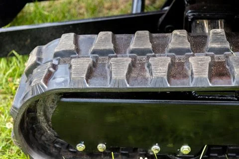 Rubber track with deep tread mounted on compact industrial vehicle Stock Photos
