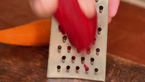 Rubbing the beetroot on metal grater Stockbeeldmateriaal 255127178