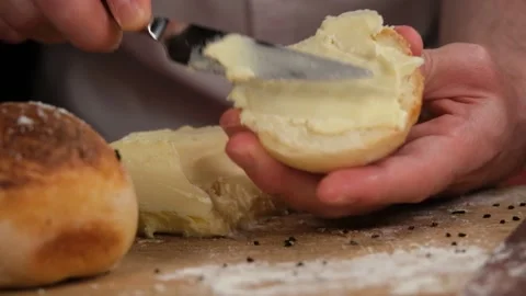 Rubbing butter on bread Stock Footage 228880461