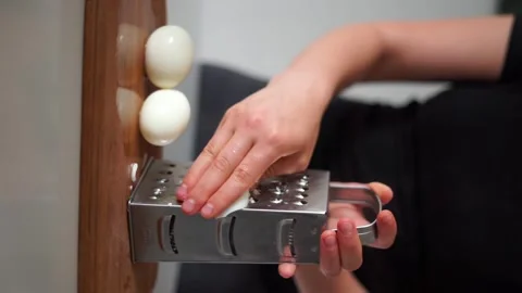 Rubbing an egg on a grater Stock Footage 244859108