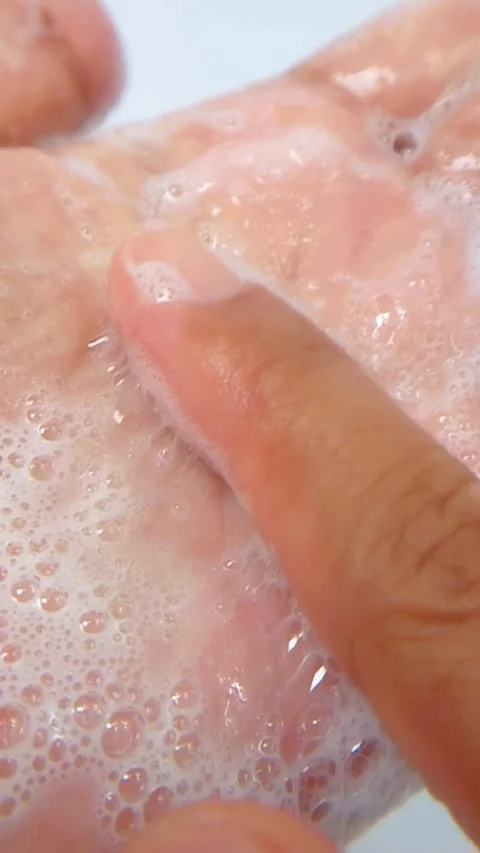 Rubbing foam bubbles on hand. Shampoo foam and beauty gel serum foam. Close.. Vídeos de archivo 335022651