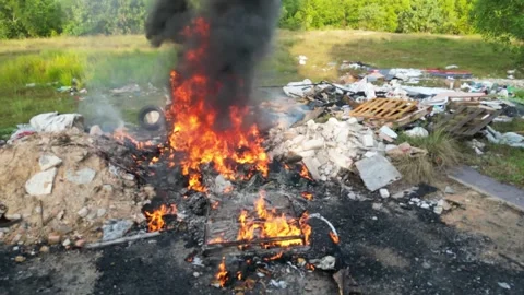 Rubbish dump is on fire in a field 動画素材 325840836