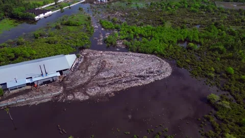 Rubbish dump polluting coastal marshland ecosystem. Smooth aerial view drone Stock-Footage 344620593