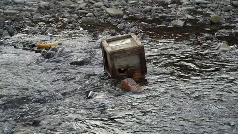 Rubbish on the river. Garbage in a mountain river. Environmental pollution Video stock 98773707