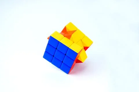 A rubik cube which is solved is displayed on an isolated white background Stock Photos