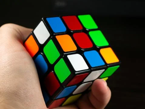 Rubik's cube in hand on a dark background Stock Photos