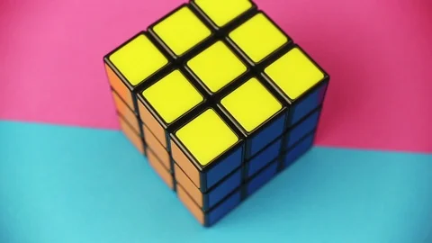 Rubik’s Cube Loop Rotating on a Colorful Cyan Magenta Background Stock Footage 104117840