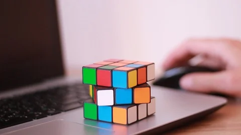 Rubik's cube on the notebook while working 스톡 동영상 99441913