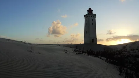 Rubjerg knude lighthouse standing on sand dunes at sunset Stock Footage 338092923