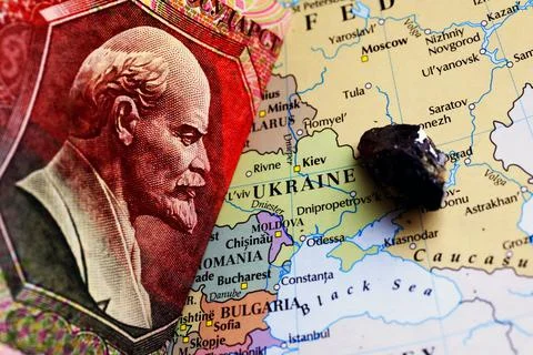 A ruble banknote and a sample of an ore deposit on top of a map showing Ukrai Stock Photos