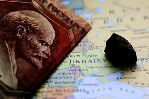 A ruble banknote and a sample of an ore deposit on top of a map showing Ukrai Stock Photos