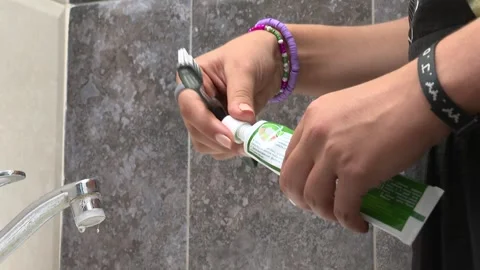 Rubs toothpaste on the brush  1 Video stock 317950980
