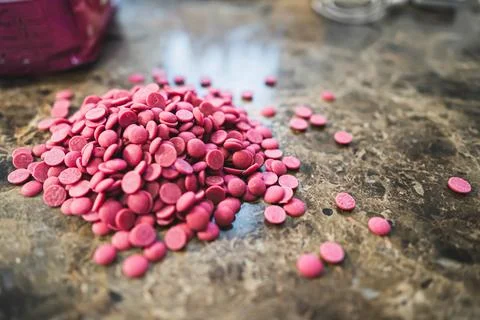 Ruby chocolate chips isolated on dark grey kitchen counter. Pile of sweets Stock Photos