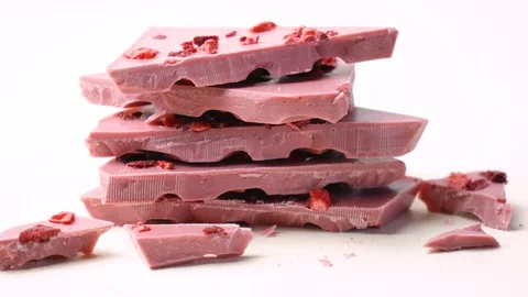 Ruby chocolate macro close up on pale pink background, rotating dolly shot. Video stock 122846363