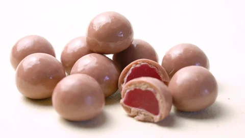 Ruby chocolate macro close up on pale pink background, rotating dolly shot. Video stock 122847900