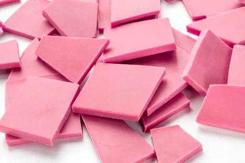 Ruby chocolate pieces, a heap on a white background Stock Photos