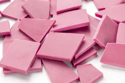 Ruby chocolate pieces, a heap on a white background Stock Photos