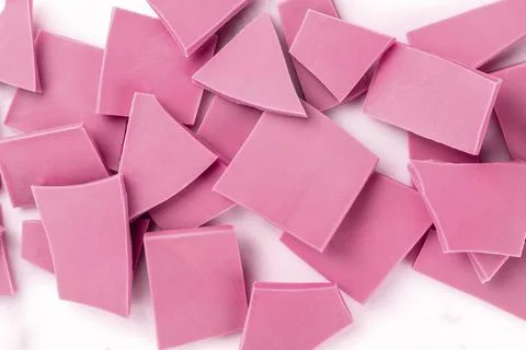 Ruby chocolate pieces, shot from the top on a white marble background Stock Photos