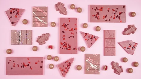 Ruby chocolate selection flat lay on pink background stop motion animation. Video stock 122853001