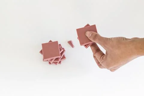 Ruby chocolate sliced and hand stacking up on white background Stock Photos