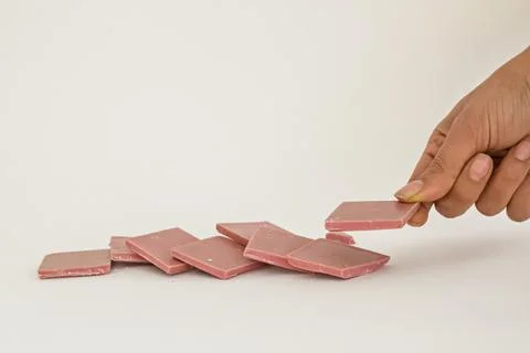 Ruby chocolate sliced and hand holding one piece on white background Stock Photos