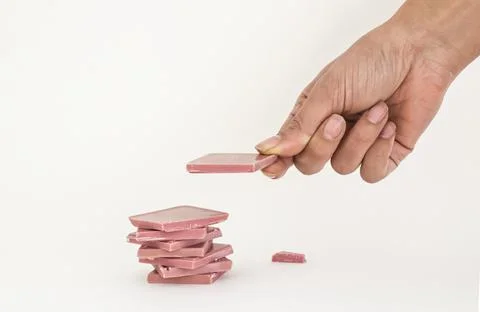 Ruby chocolate sliced and hand stacking up on white background Stock Photos