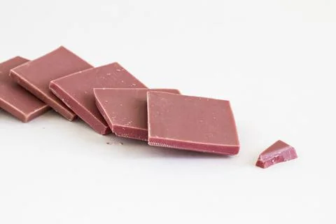 Ruby chocolate sliced on white surface with copy space Stock Photos