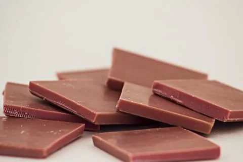 Ruby chocolate sliced on white surface with copy space Stock Photos
