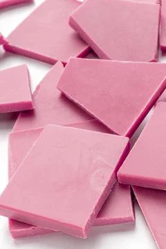 Ruby chocolate slices, a close-up of a heap on a white background Stock Photos