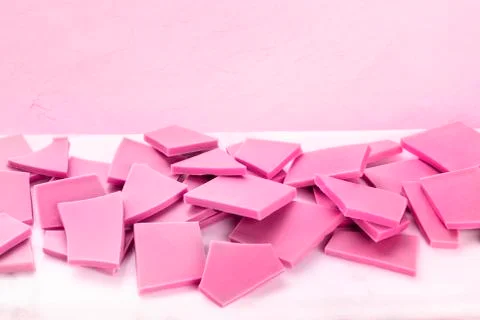 Ruby chocolate slices on a pink background with a place for text Stockfoto's