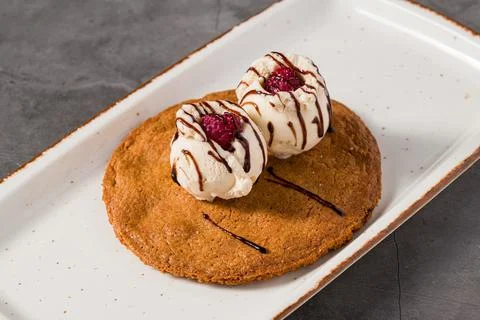 Ruby cookie dessert topped with vanilla ice cream and chocolate Stock Photos