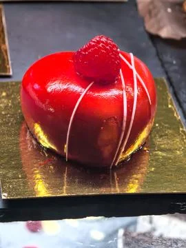 Ruby glazed cake crowned with a fresh raspberry 스톡 사진