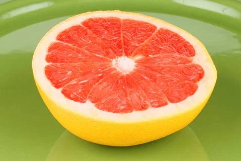  Ruby grapefruit close-up Close-up of a half cut ruby grapefruit on a gree... 스톡 사진