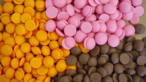 Ruby orange and dark chocolate callets closeup tempered chocolate confectionery Video stock 239382822