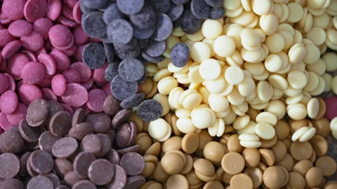 Ruby white and dark chocolate callets closeup - Tempered chocolate confectionery Video stock 239383033