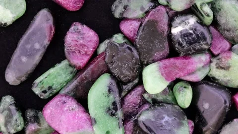 Ruby zoisite jewel stones heap up texture on black background. Moving right s Stock Footage 220690214