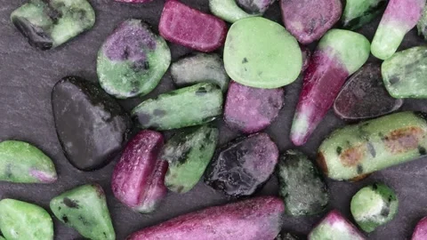 Ruby zoisite rare jewel stones texture on black stone background. Moving righ Stock Footage 221361943