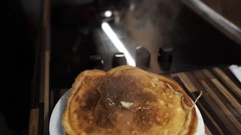 Ruddy pancakes cool down on a plate with steam Stock Footage 276680133
