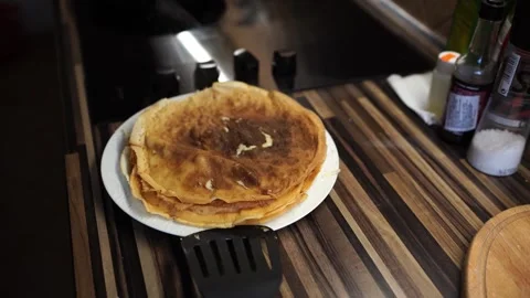 Ruddy pancakes lie in a stack on a plate on the table and steam Stock Footage 269844391