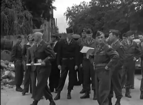 RUESSELSHEIM, GERMANY - 1945: Roadside rubble - Men study a large paper sheet Stock Footage 344487689