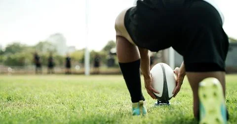 Rugby ball, hands and player on field with kick, start game or match for co.. Foto stock