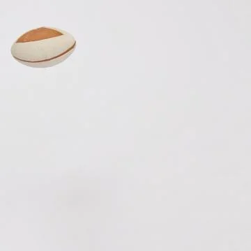 Rugby ball on a white background in the upper left with copy space. Minimal.. Stock Photos