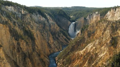 Rugged amber colored gorge frames beautiful Yellowstone Falls Stock Footage 141810600