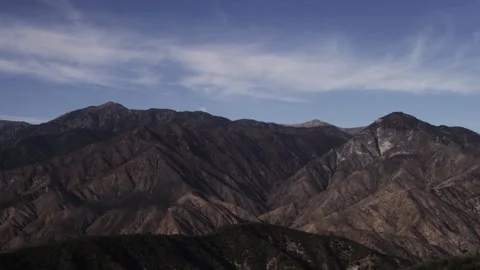 Rugged brown mountain range under blue sky with clouds Stock Footage 329656921