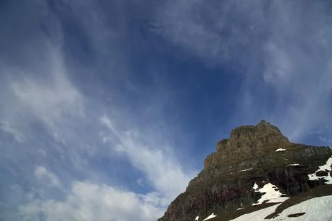 Rugged Clements Mountain Peak Under Dramatic Wispy Sky in Glacier National Park Stock Photos
