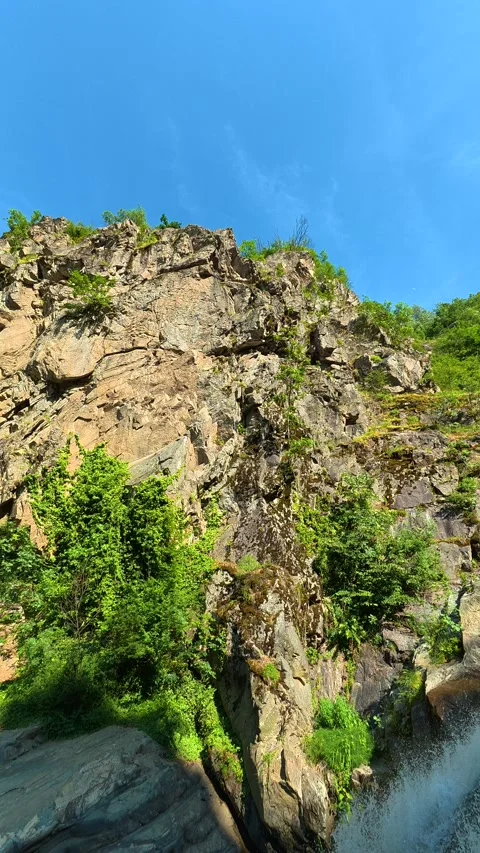 Rugged cliff drops into rushing waterfall. Vucjanka Canyon, Serbia. Vertical Stock Footage 341132777