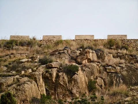 Rugged cliff face adorned with construction blocks ideal for geological Stock Photos