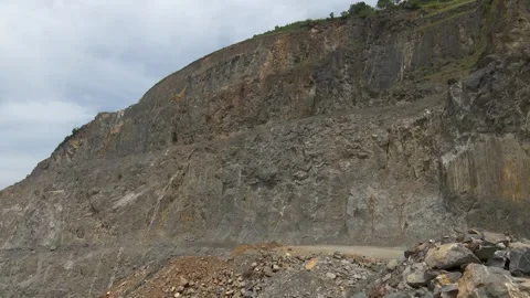 Rugged cliff face in an open pit mining quarry a view of an expansive rocky Stock Footage 340264483